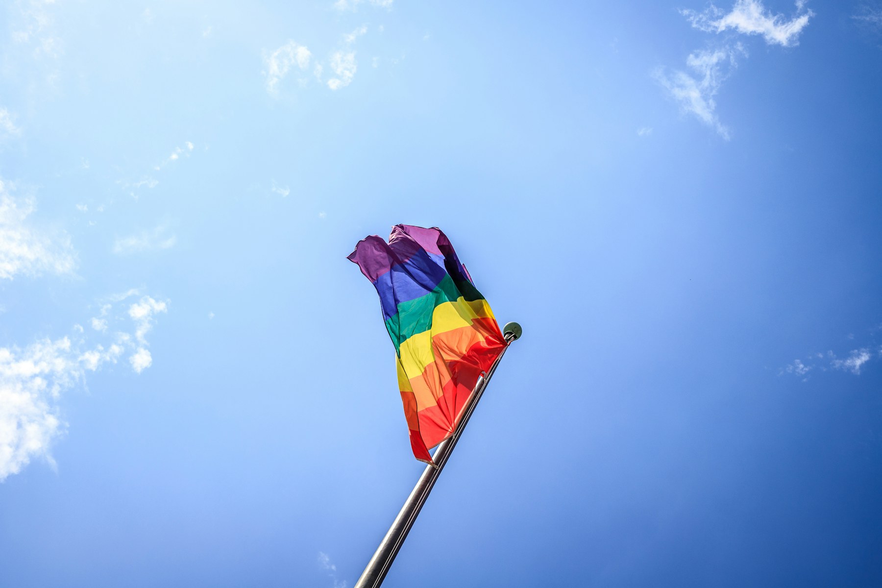 Pride flag against blue sky
