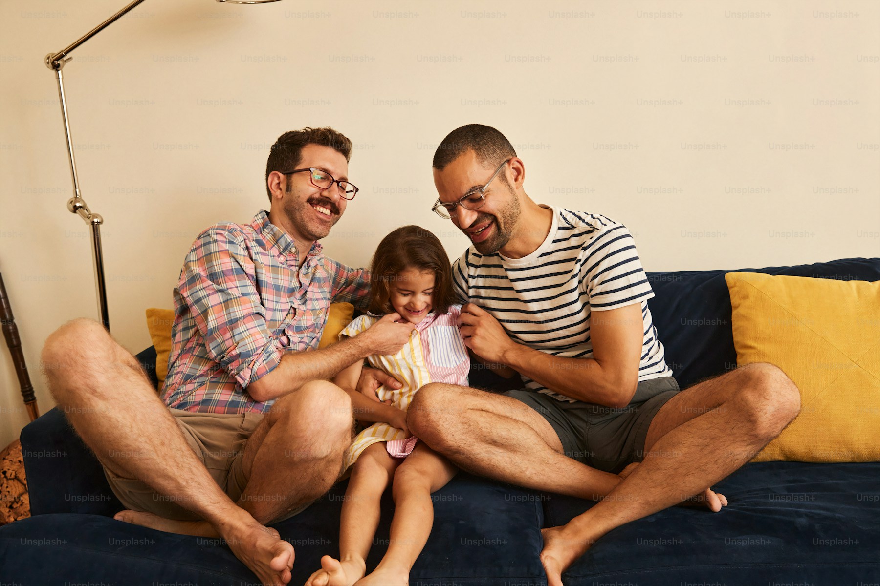 Gay male couple with their daughter at home